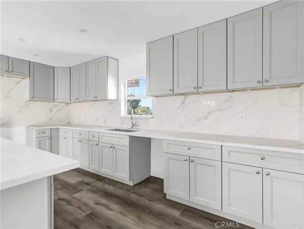 a room with a sink cabinets and wooden floor
