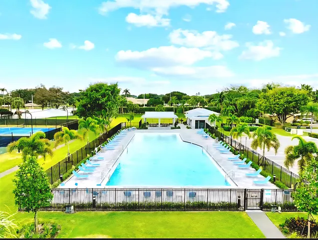 a view of a swimming pool with lawn chairs under an umbrella