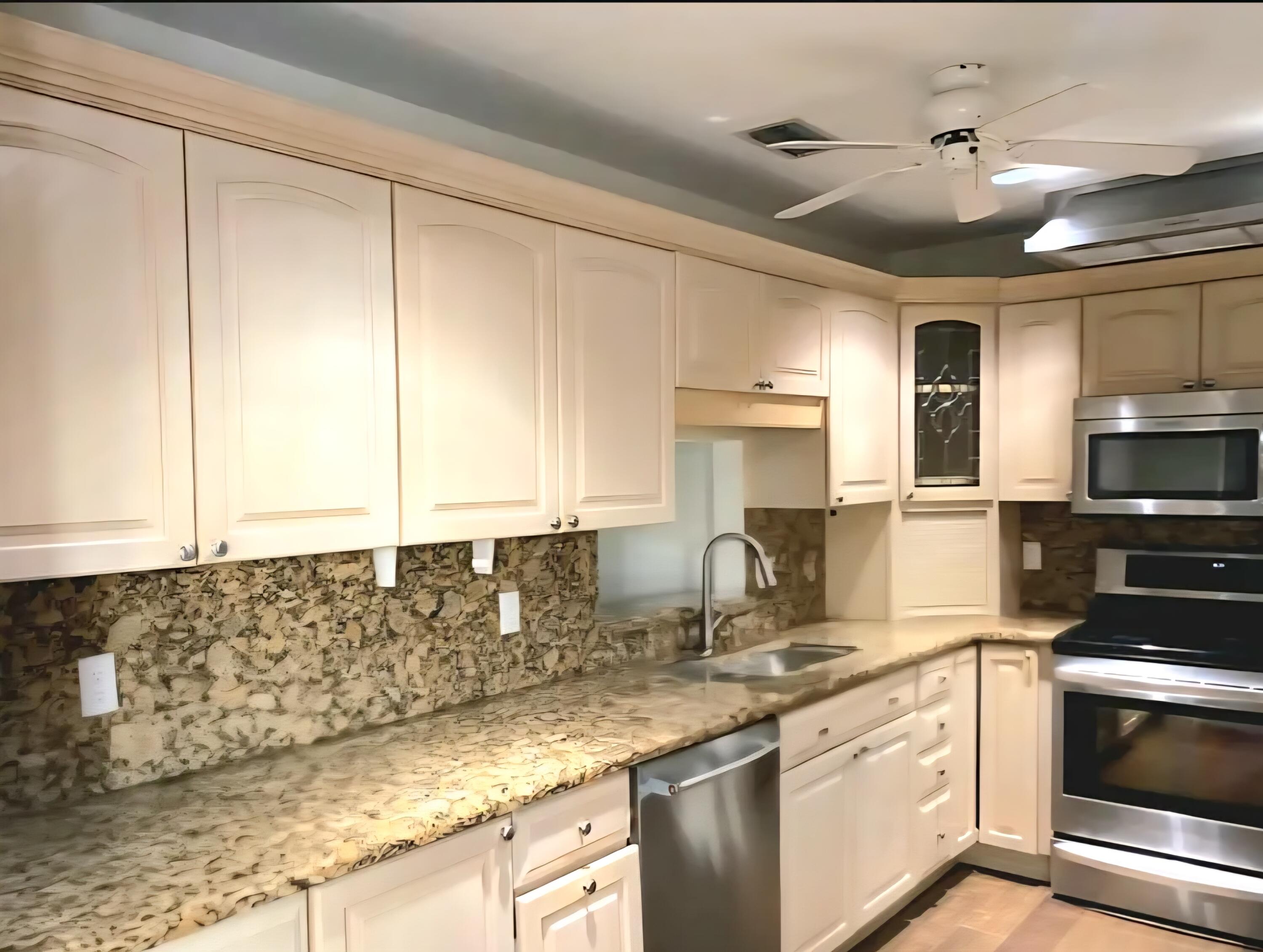 19323 Carolina Circle Boca Raton, FL 33434 - Photo 7 of 24 a kitchen with stainless steel appliances granite countertop a sink a stove and a microwave