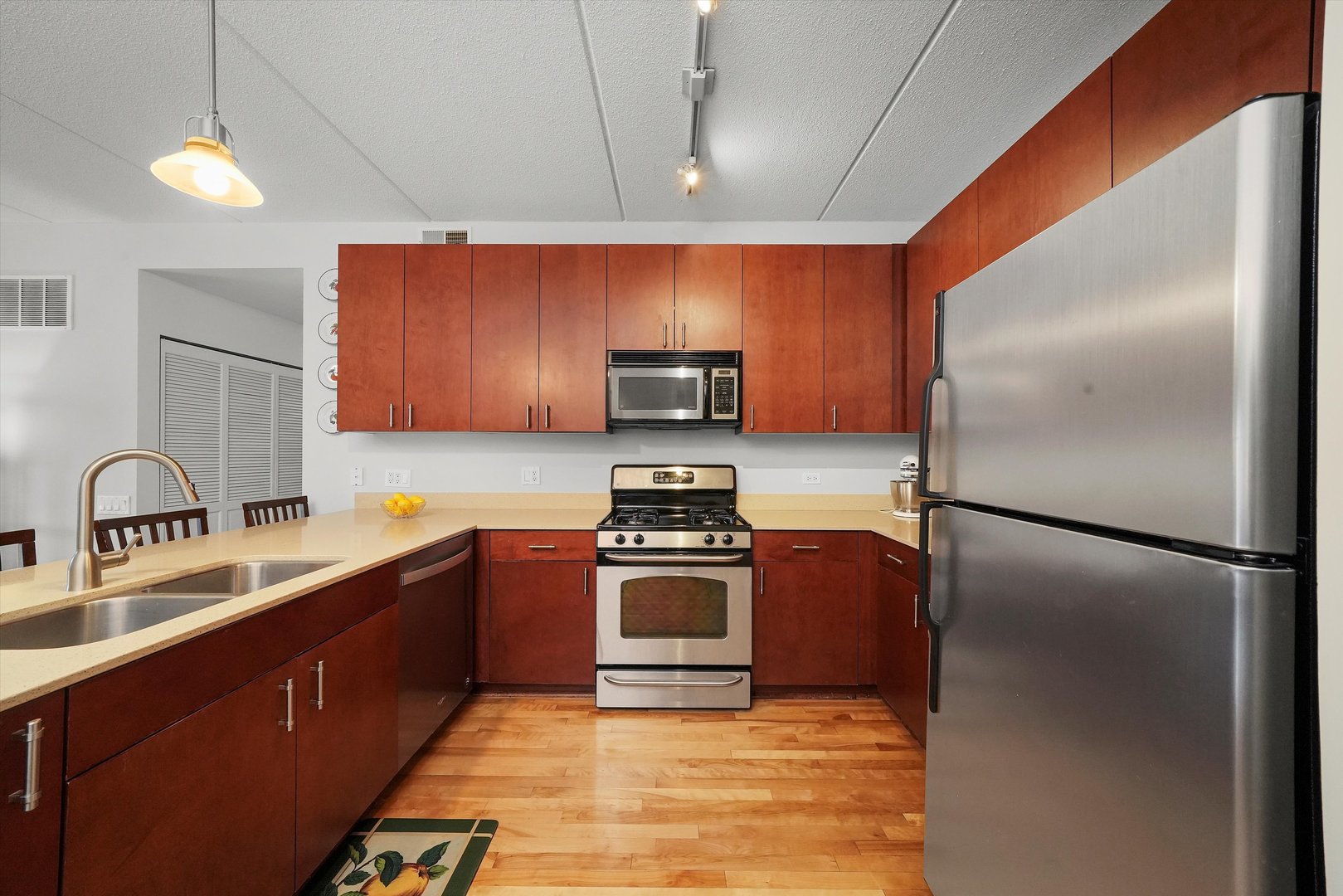 4311 North Sheridan Road, Unit 306 Chicago, IL 60613 - Photo 3 of 17 a kitchen with stainless steel appliances granite countertop a refrigerator a stove a sink and a microwave