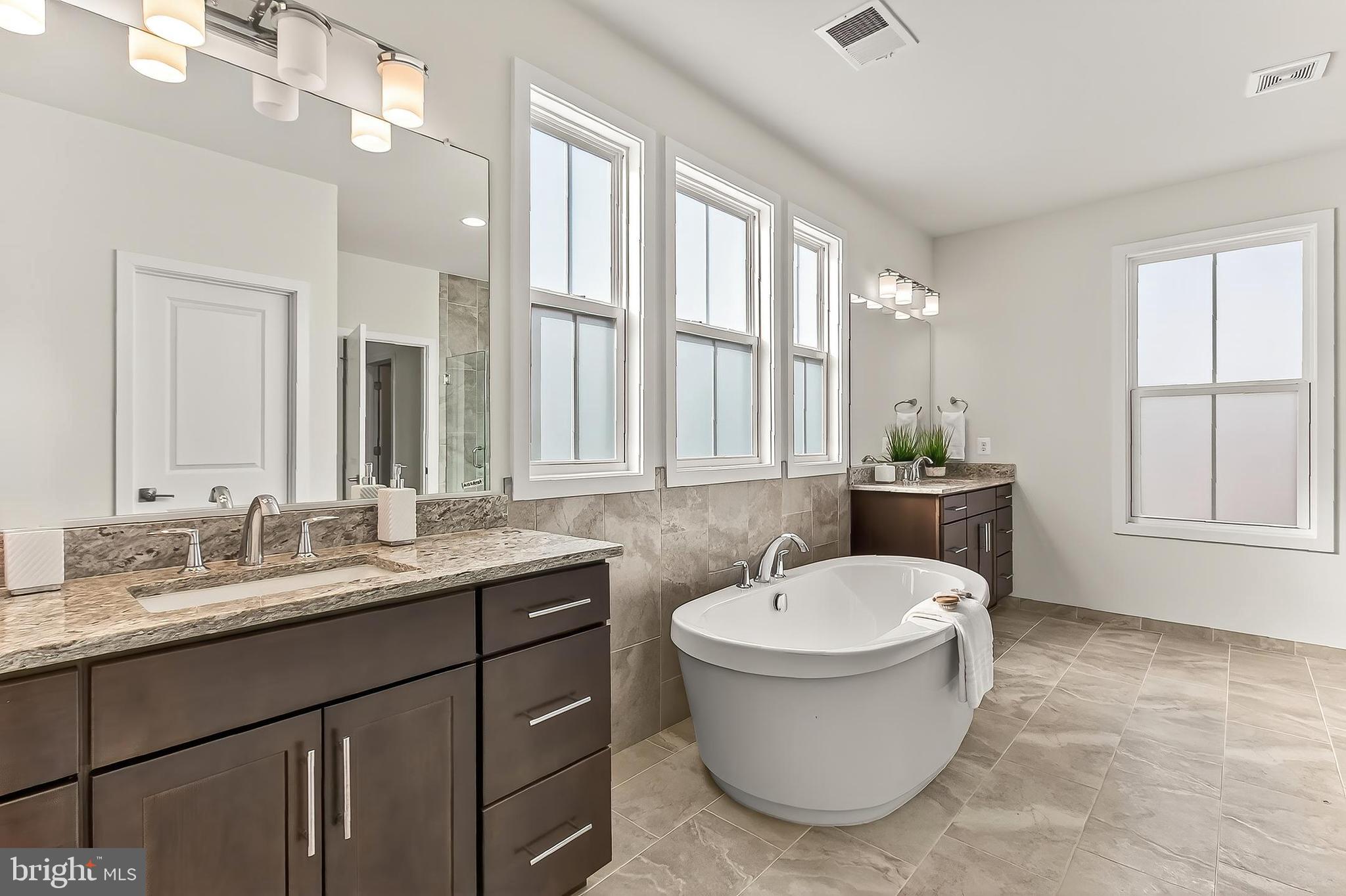 41424 Gentle Wind Place Aldie, VA 20105 - Photo 45 of 83 a bathroom with a granite countertop sink and mirror with bathtub