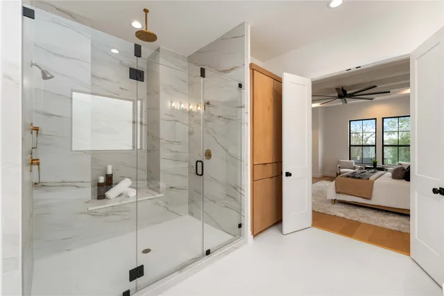 a bathroom with a tub shower and mirror