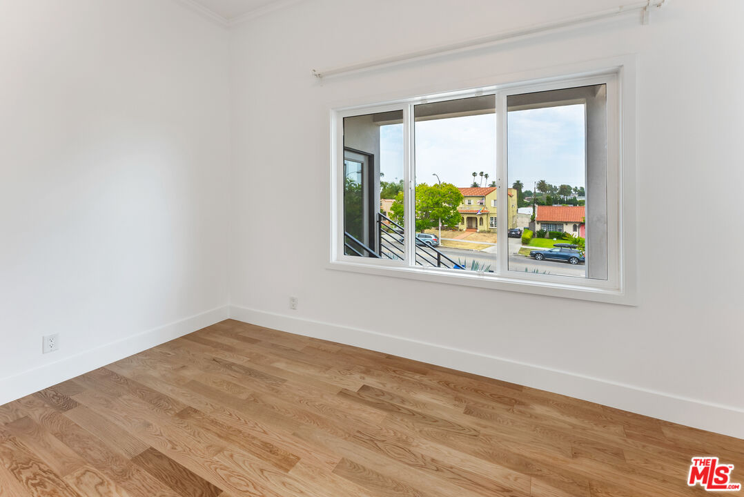 1253 South Rimpau Boulevard Los Angeles, CA 90019 - Photo 62 of 71 an empty room with wooden floor and a window