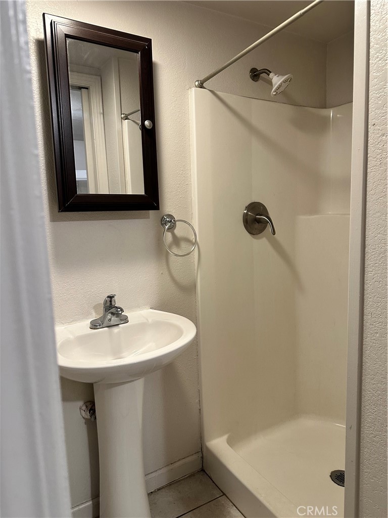 7459 Ysmael Villegas Street Riverside, CA 92504 - Photo 3 of 8 a bathroom with a sink a mirror and a bathtub