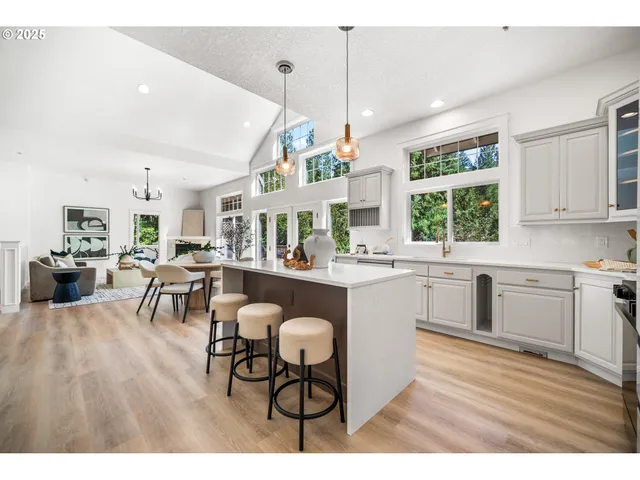 a kitchen with a table chairs a sink dishwasher window and cabinets