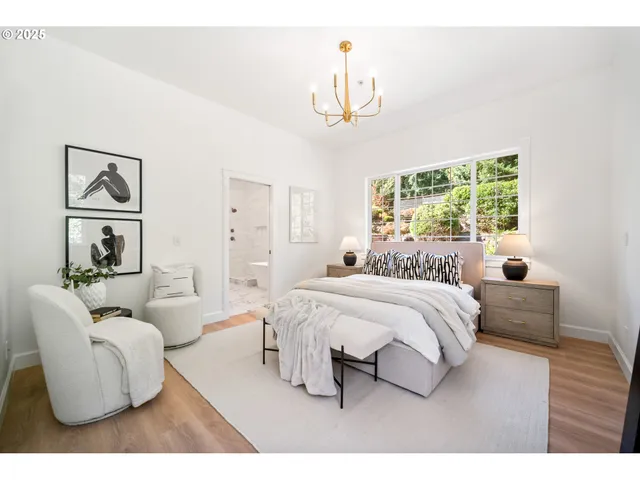a spacious bedroom with a bed a couch and a chandelier