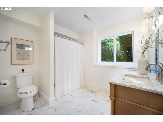a bathroom with a sink a toilet and a window
