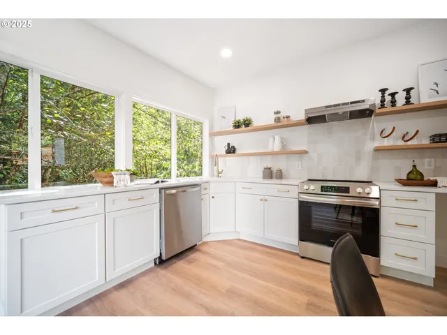 a kitchen with a stove a sink and a window