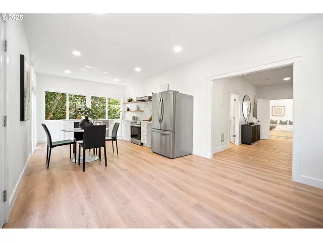 a open kitchen with stainless steel appliances refrigerator dining table and chairs