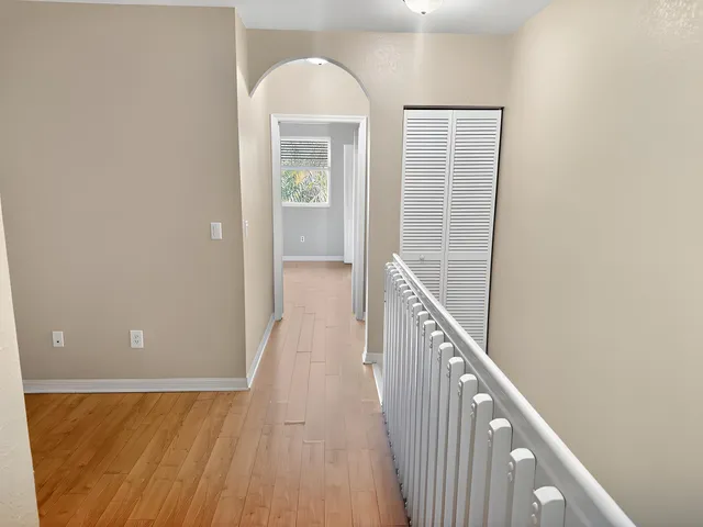 a view of a hallway with wooden floor and staircase