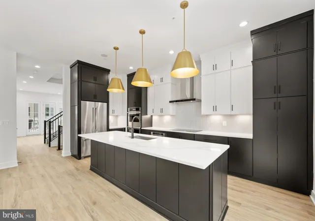 a kitchen with stainless steel appliances granite countertop a sink a stove and a wooden floors