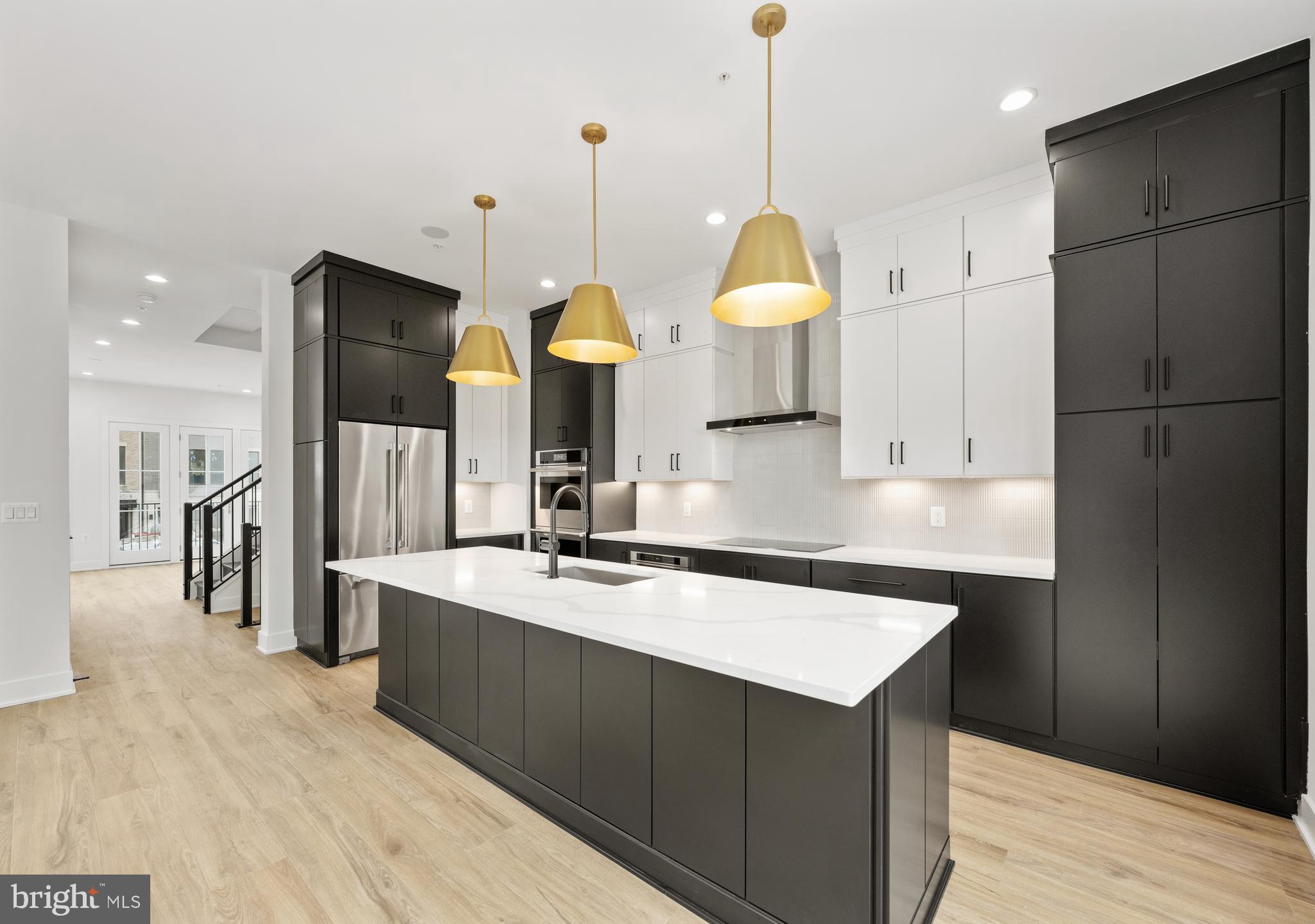 8616 Erdem Place Chevy Chase, MD 20815 - Photo 3 of 12 a kitchen with stainless steel appliances granite countertop a sink a stove and a wooden floors