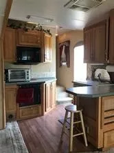 a kitchen with a stove and a wooden cabinets