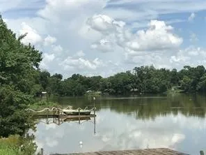 a view of a lake in between two and trees