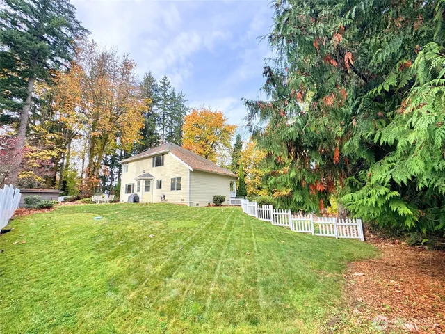 a front view of a house with a yard and trees