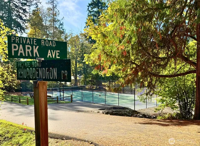 a view of a street sign under a large tree