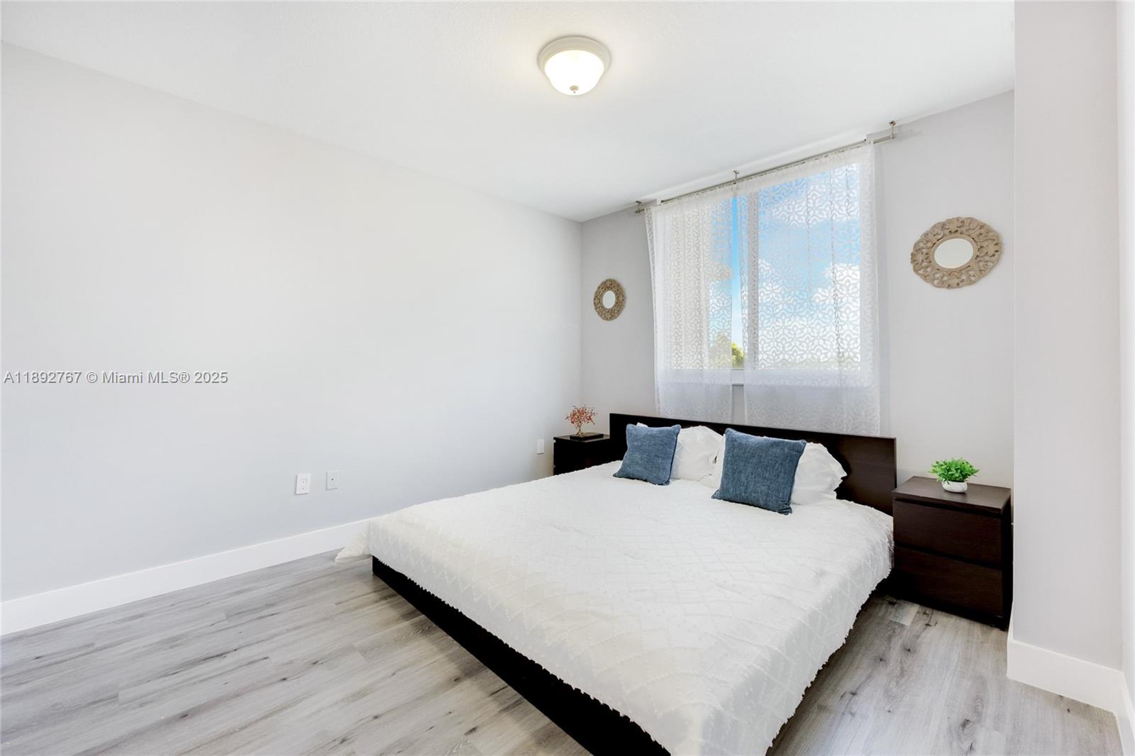 2775 Northeast 187th Street, Unit 309 Aventura, FL 33180 - Photo 6 of 21 a bedroom with a bed and a night stand