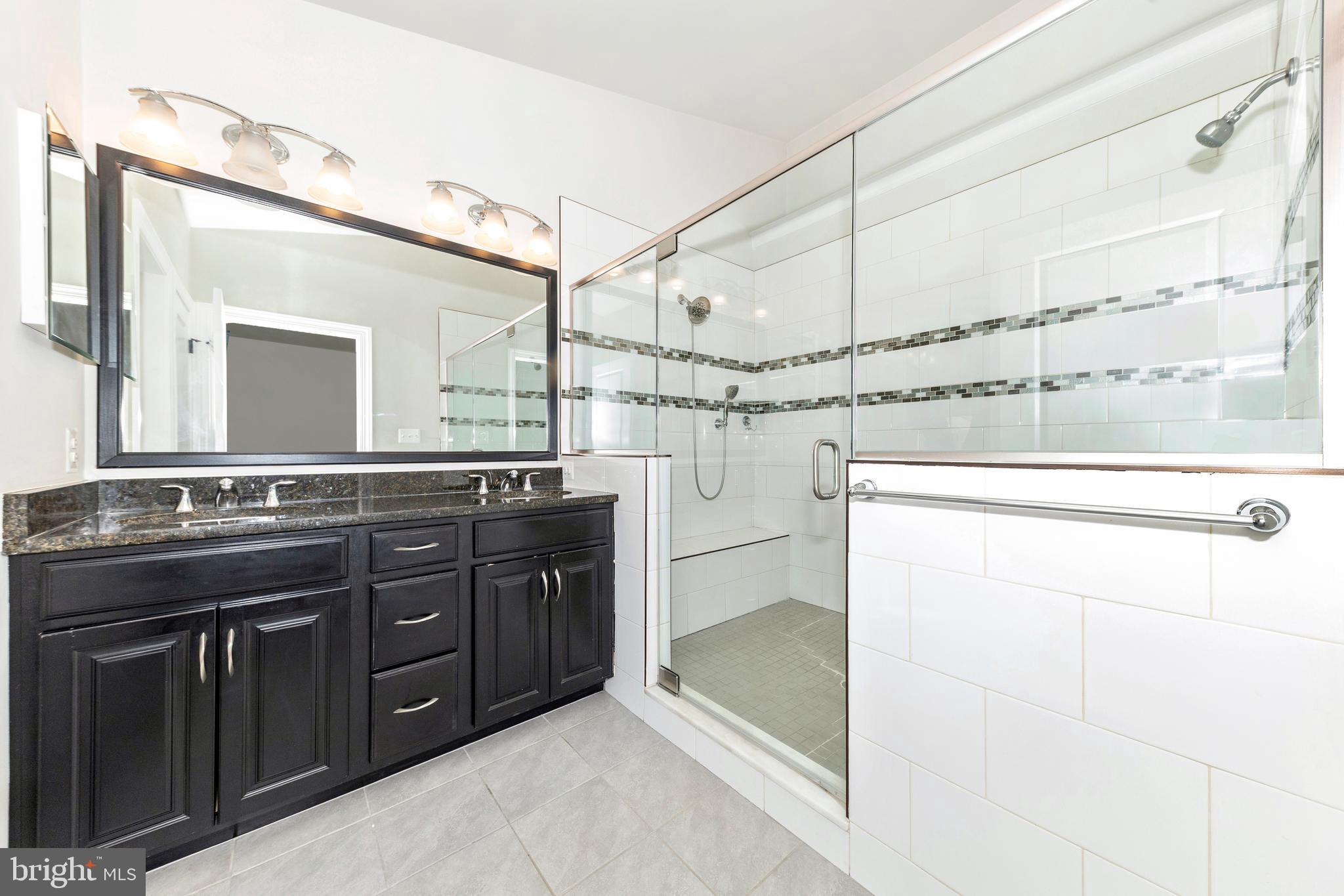 2325 Asberry Road Hanover, MD 21076 - Photo 26 of 65 a spacious bathroom with a granite countertop sink and a mirror