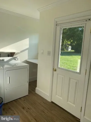 a utility room with wooden floor washer and dryer