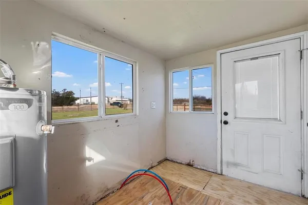a view of a bedroom with wooden floor and windows