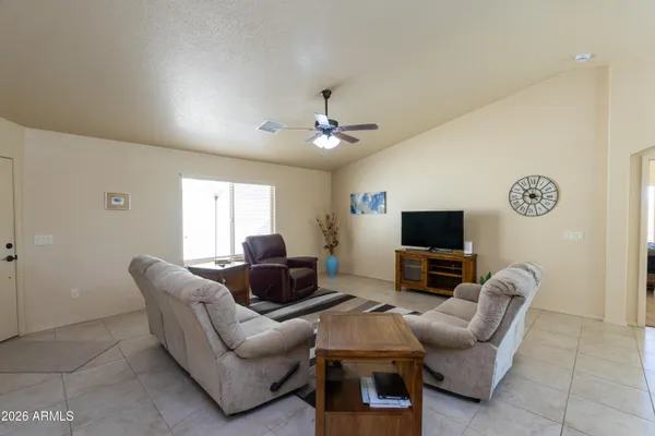 a living room with furniture a flat screen tv and a window