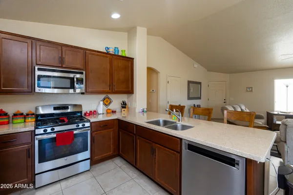 a kitchen with stainless steel appliances granite countertop a refrigerator and a stove top oven