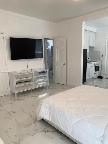 a bedroom with a bed and a flat screen tv