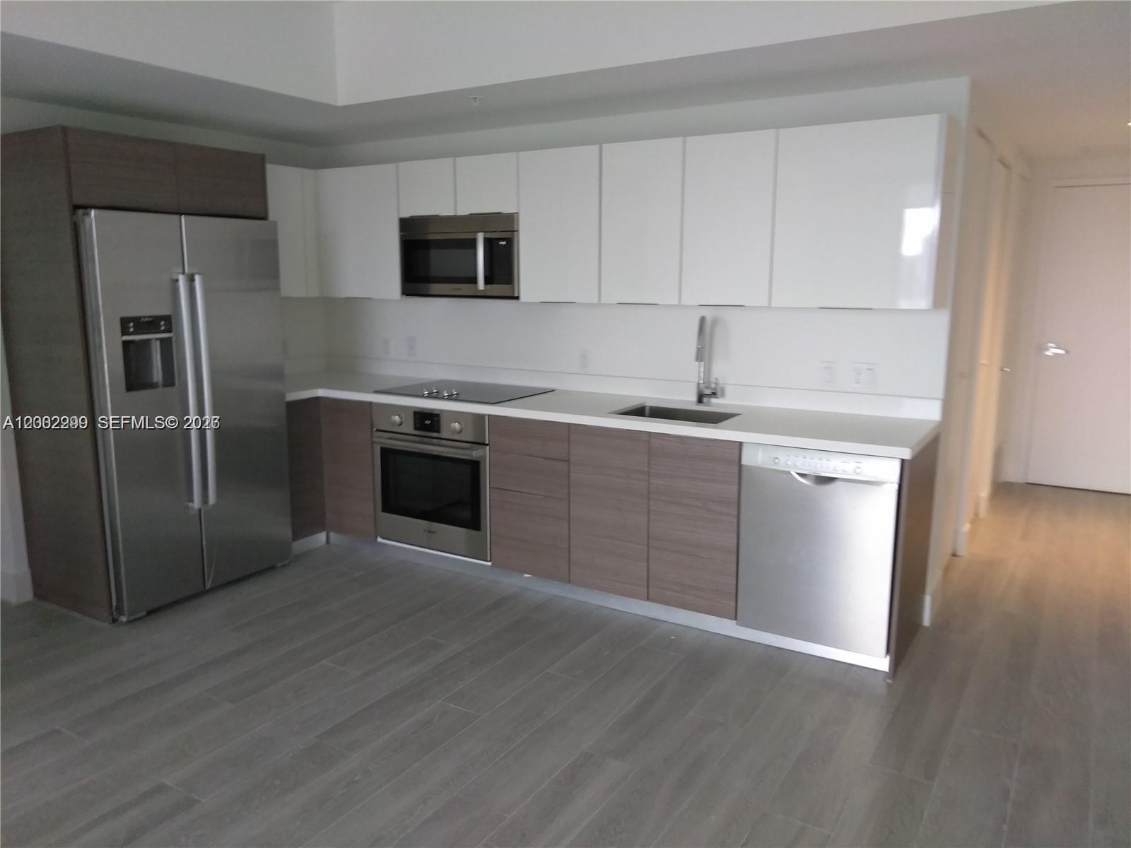 1010 Southwest 2nd Avenue, Unit 1901 Miami, FL 33130 - Photo 7 of 8 a kitchen with stainless steel appliances granite countertop a sink stove and refrigerator