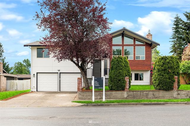 a front view of a house with a yard and garage