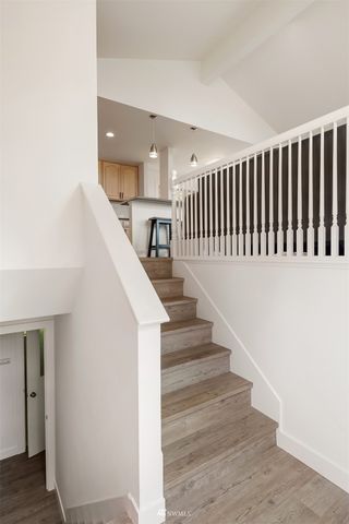 a view of staircase with wooden floor and white walls