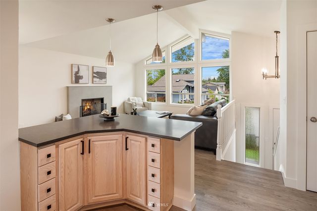 a kitchen with stainless steel appliances granite countertop a sink and a granite counter tops with wooden floors