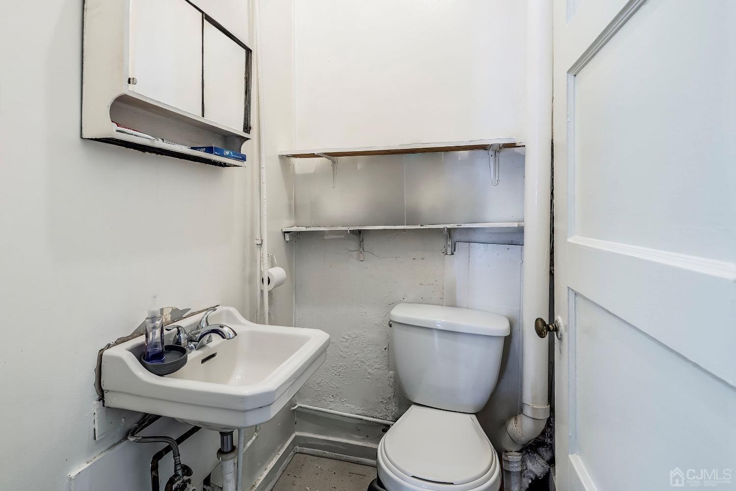 144 Main Street Butler, NJ 07405 - Photo 11 of 24 a bathroom with a toilet a sink and a mirror
