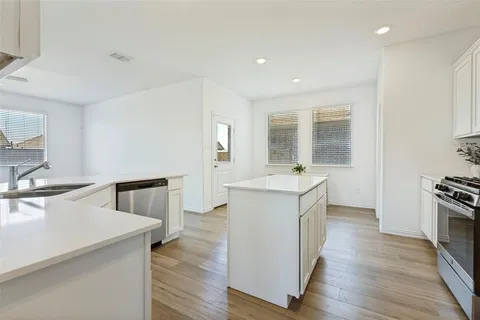 a kitchen with sink stove and wooden floor