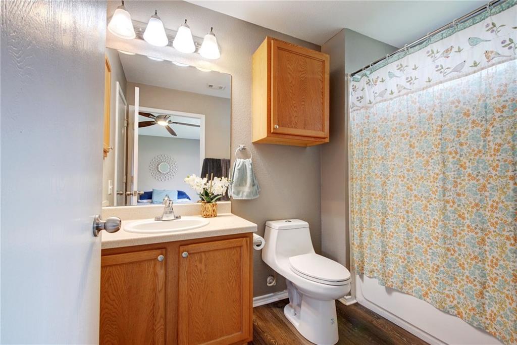 13905 Briarcreek Loop Manor, TX 78653 - Photo 9 of 25 Full bath with vanity, dark wood-type flooring, and shower / bath combo with shower curtain