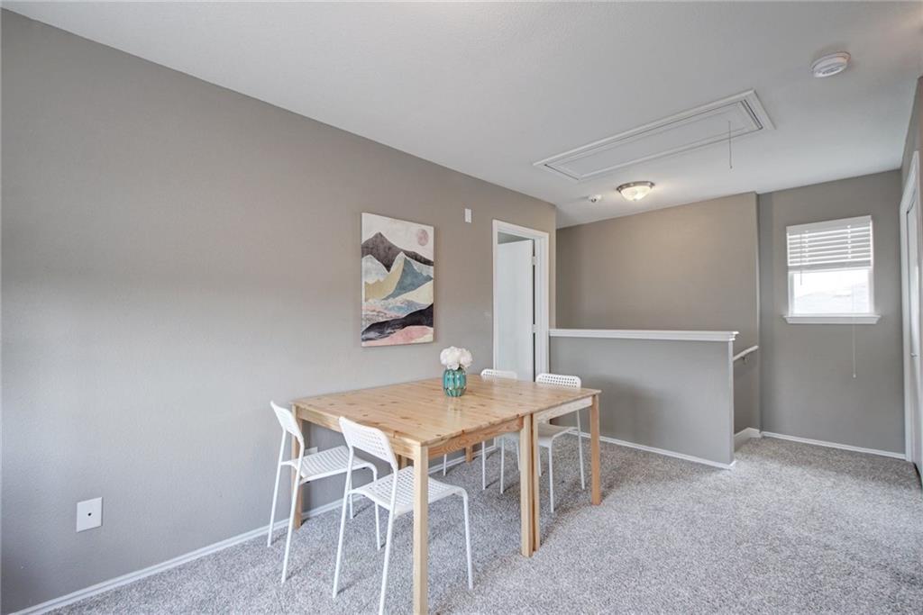 13905 Briarcreek Loop Manor, TX 78653 - Photo 10 of 25 Dining space with light carpet and attic access