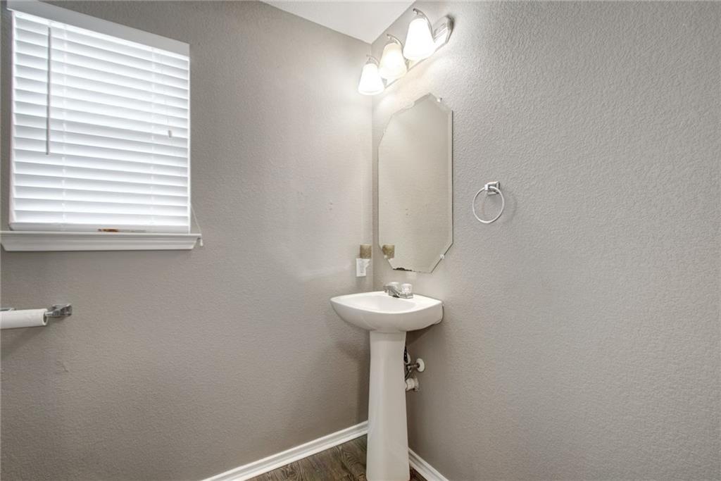 13905 Briarcreek Loop Manor, TX 78653 - Photo 17 of 25 Half bath with a textured wall and dark wood-style flooring