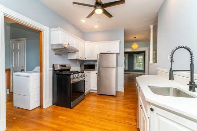 a kitchen with a refrigerator sink and cabinets