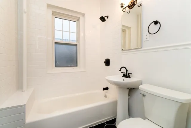 a bathroom with a sink mirror toilet and bathtub