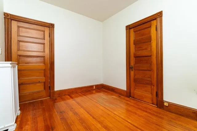 an empty room with wooden floor and closet
