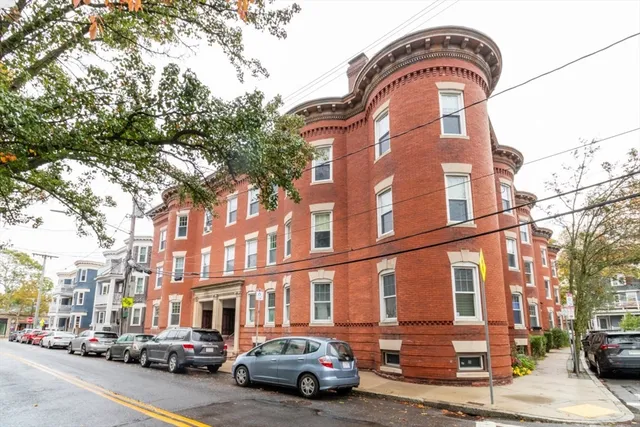 a couple of cars parked in front of brick building