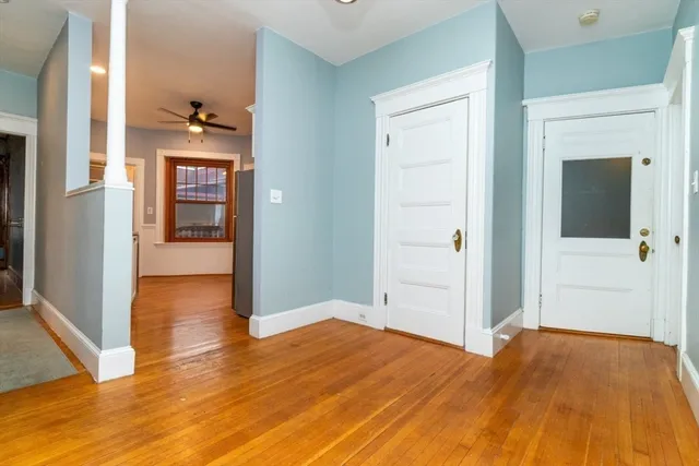 a view of a hallway with wooden floor and closet