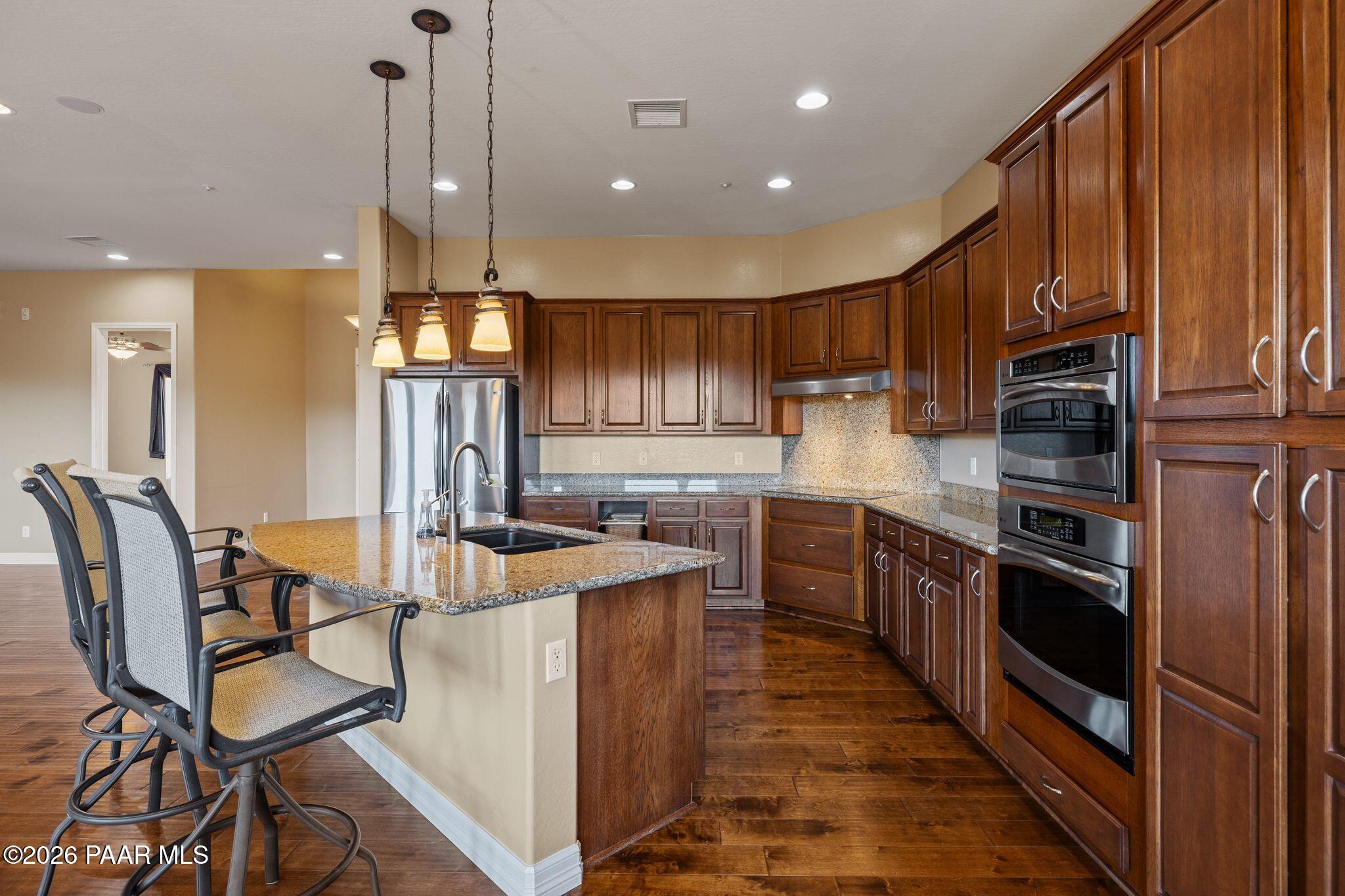 15411 East Rough Rider Ridge Mayer, AZ 86333 - Photo 11 of 57 a kitchen with stainless steel appliances granite countertop sink stove top oven and cabinets