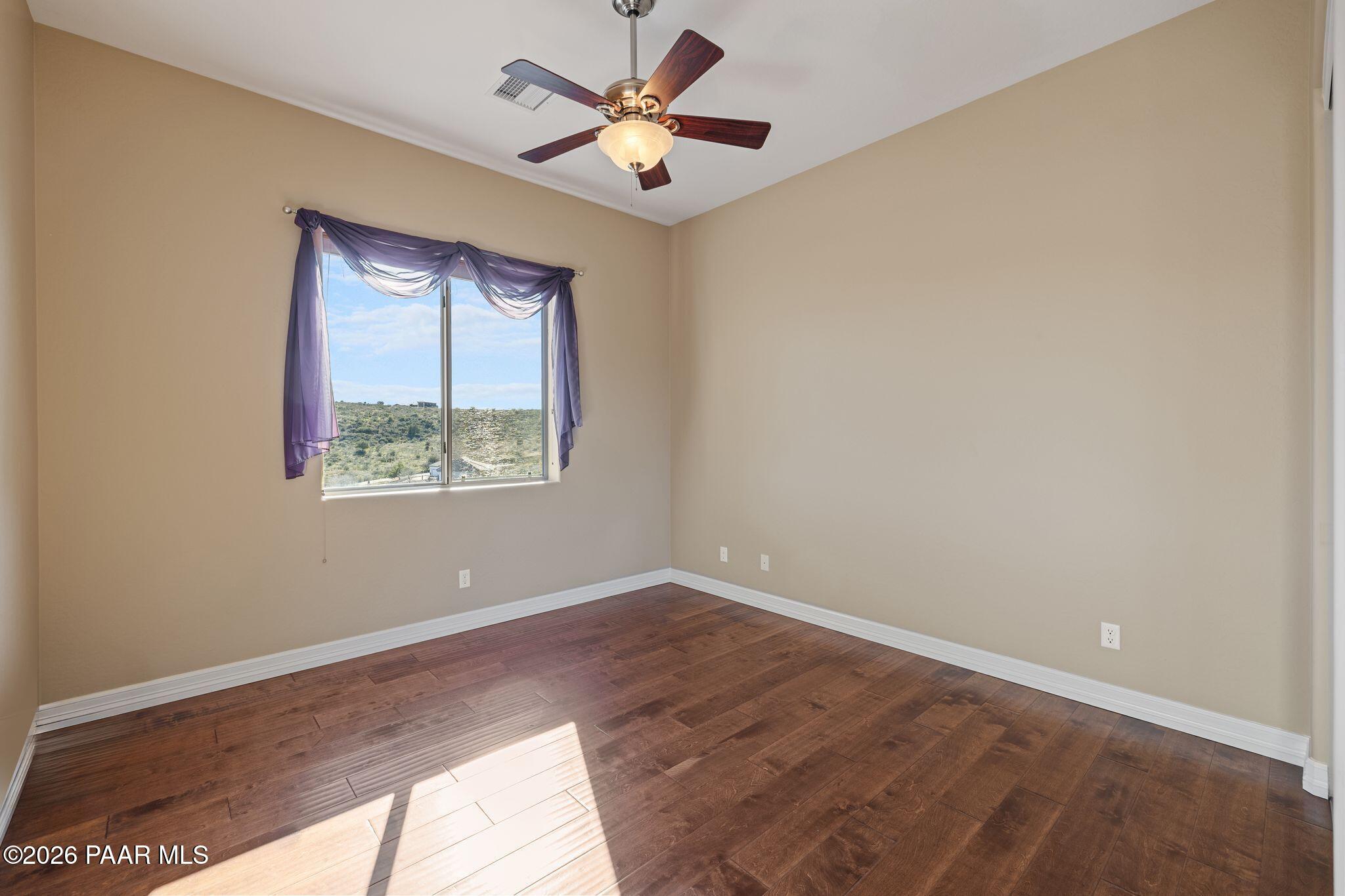 15411 East Rough Rider Ridge Mayer, AZ 86333 - Photo 36 of 57 an empty room with a window and a ceiling fan