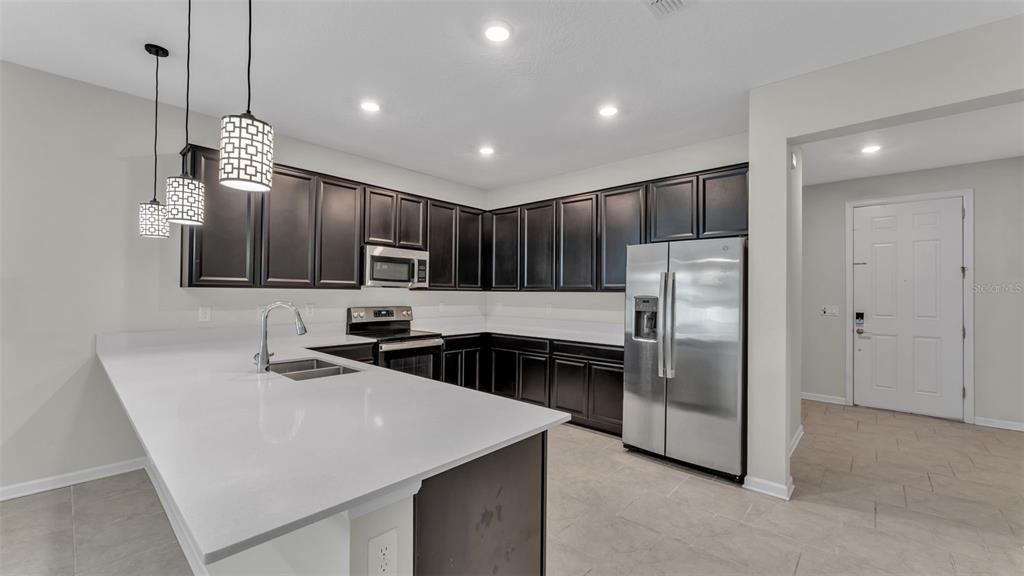 244 Pershing Street Bartow, FL 33830 - Photo 4 of 32 a kitchen with stainless steel appliances granite countertop a refrigerator a sink a stove and a refrigerator