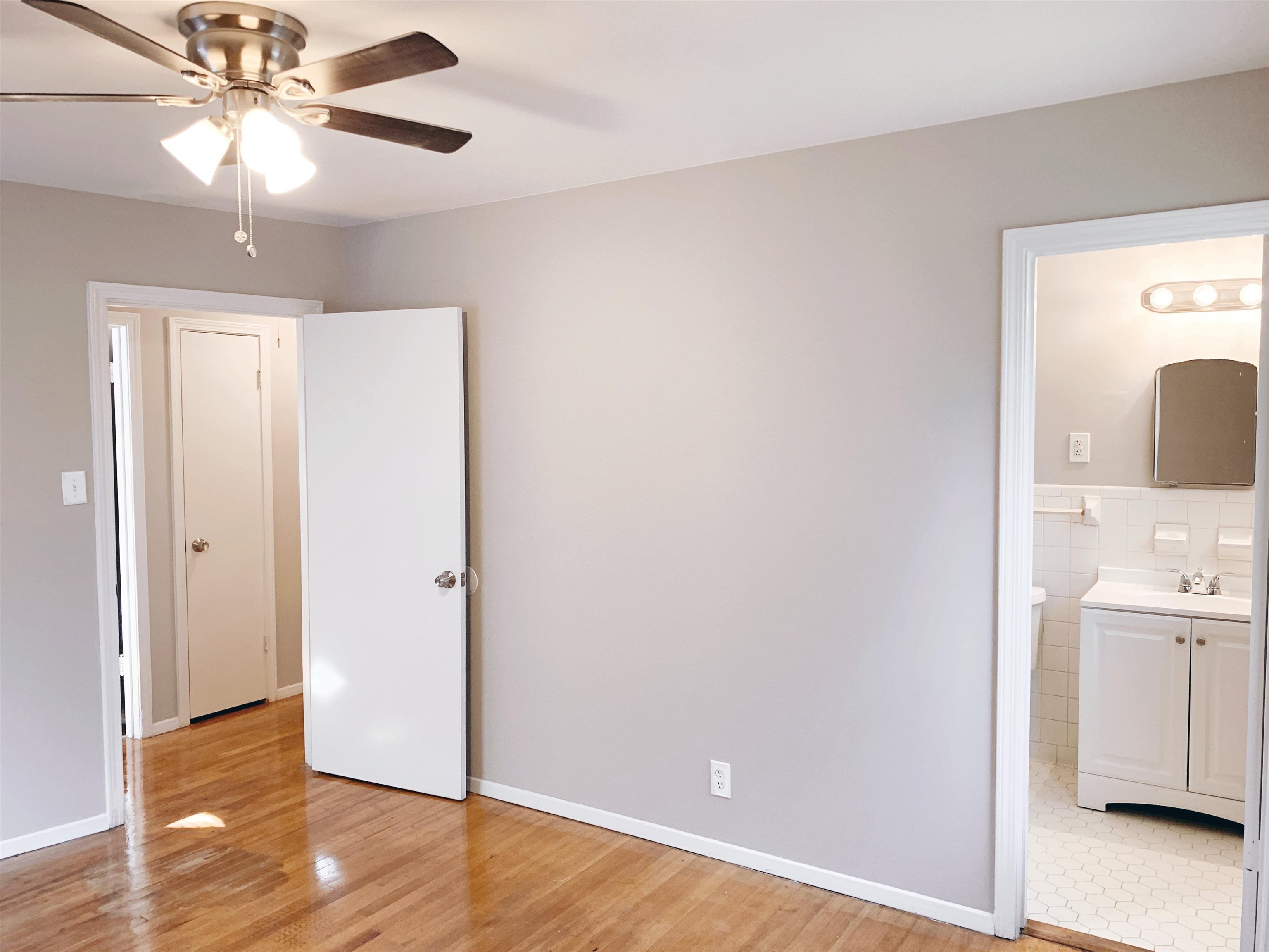 1084 Rutland Road Memphis, TN 38114 - Photo 6 of 13 Unfurnished bedroom with ceiling fan, light wood-type flooring, and ensuite bathroom