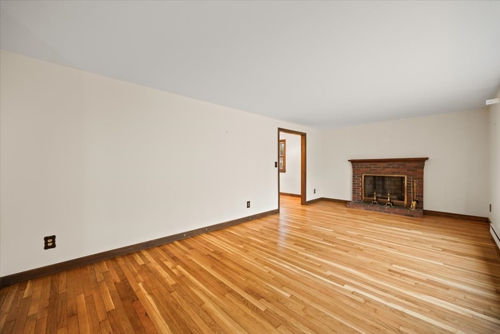 37 Woodlock Road Hingham, MA 02043 - Photo 9 of 34 a view of empty room with wooden floor and fireplace