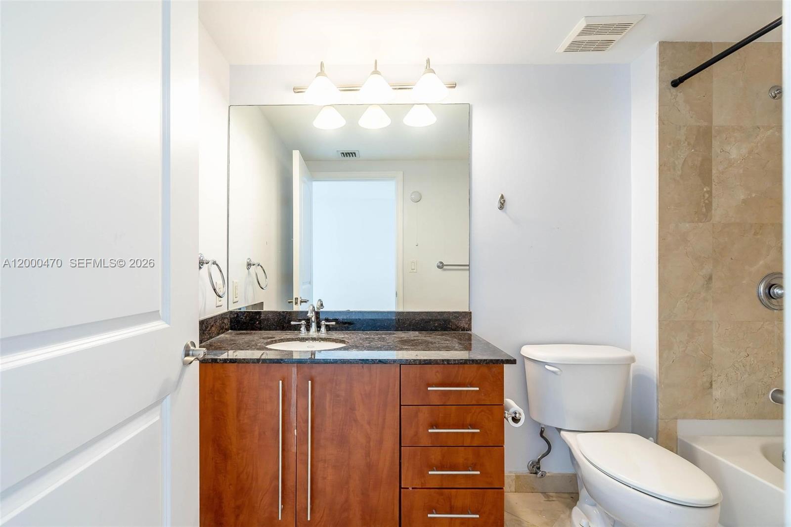 7350 Southwest 89th Street, Unit 1707S Miami, FL 33156 - Photo 13 of 45 a bathroom with a granite countertop sink toilet mirror and a bathtub