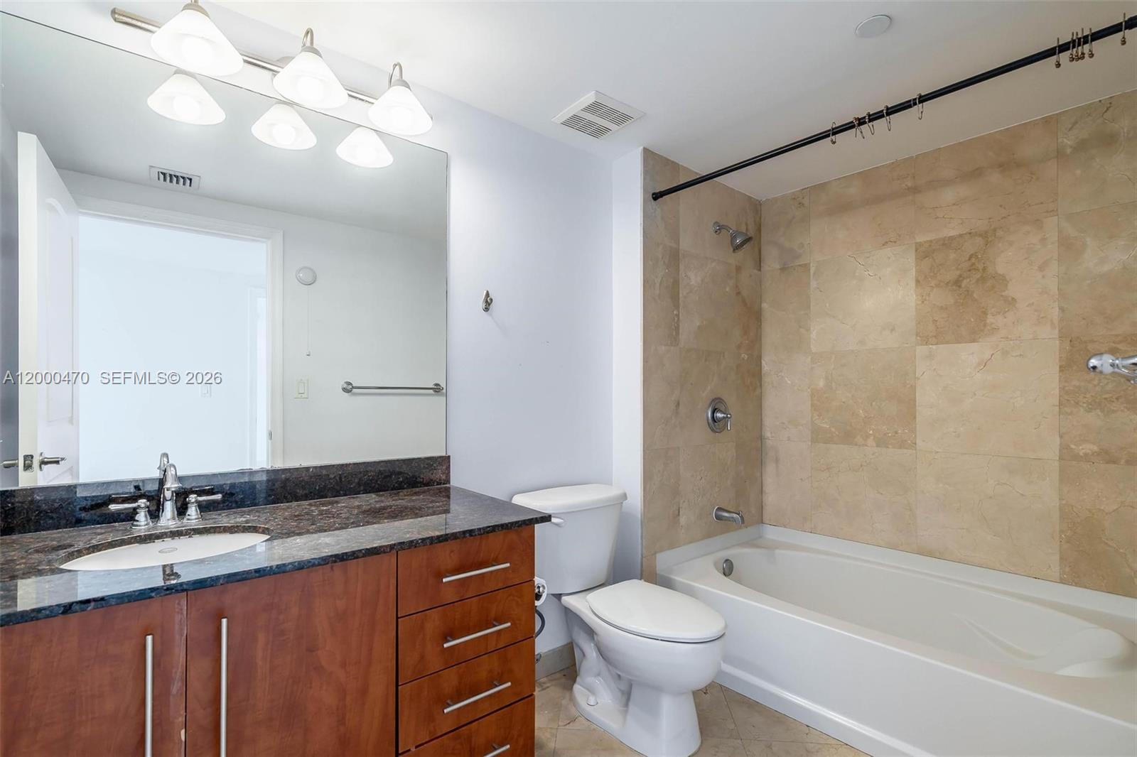 7350 Southwest 89th Street, Unit 1707S Miami, FL 33156 - Photo 14 of 45 a bathroom with a granite countertop sink toilet mirror and bathtub