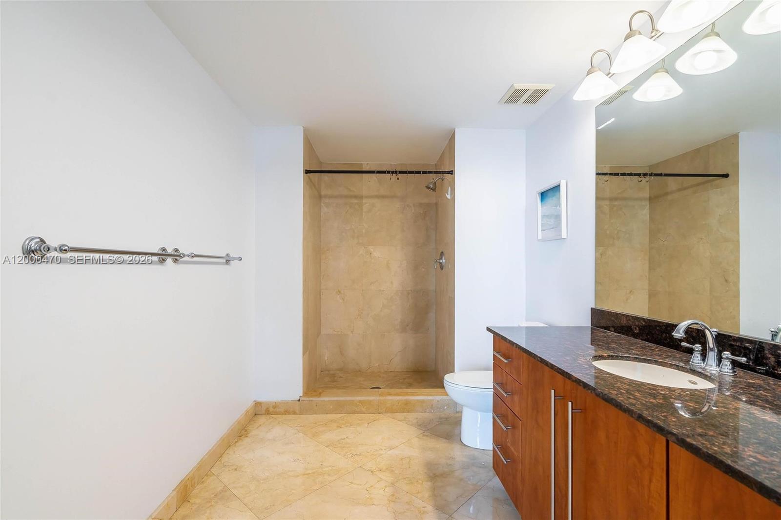 7350 Southwest 89th Street, Unit 1707S Miami, FL 33156 - Photo 23 of 45 a bathroom with a granite countertop sink a mirror and a shower