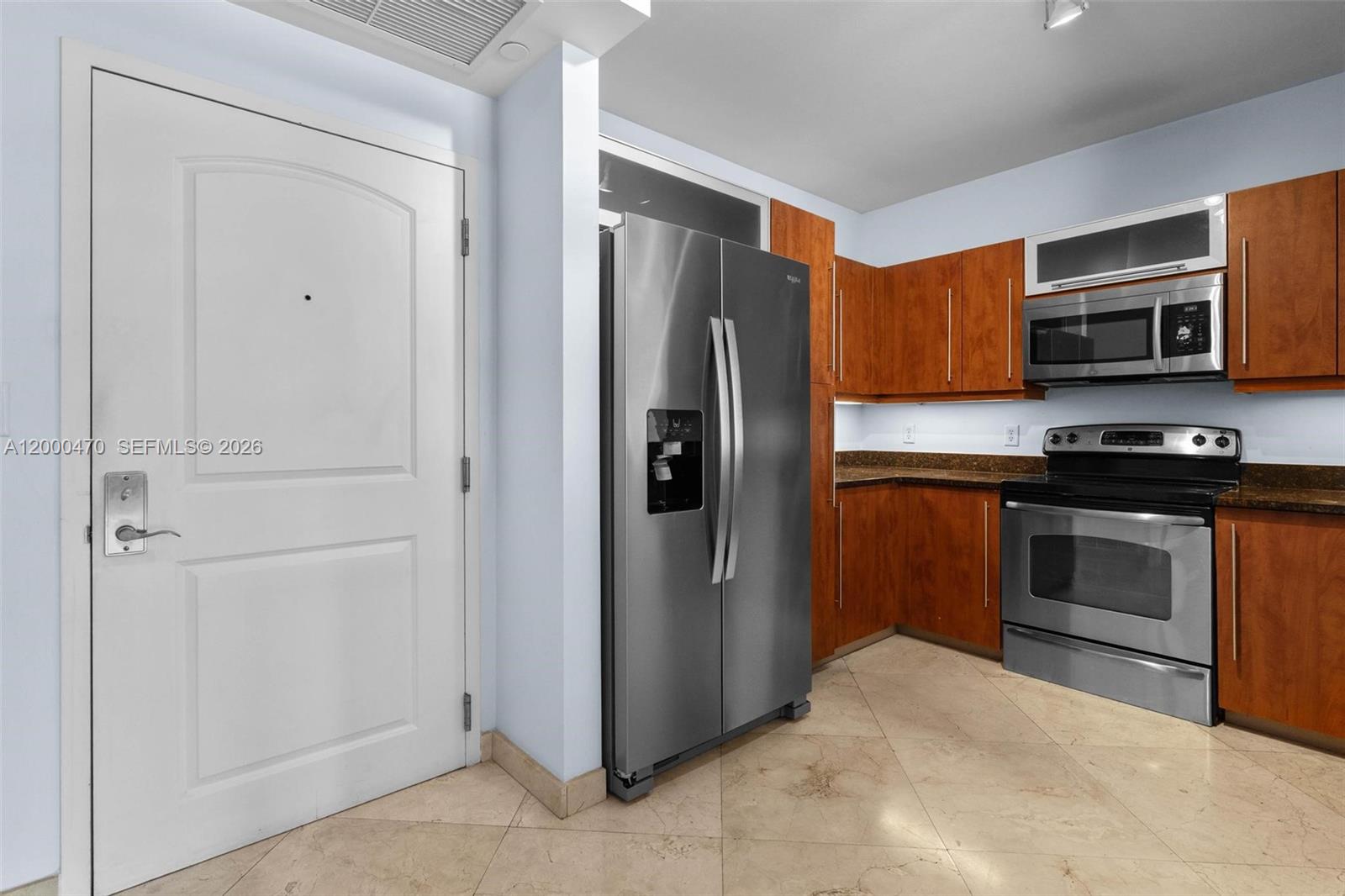 7350 Southwest 89th Street, Unit 1707S Miami, FL 33156 - Photo 43 of 45 a kitchen with stainless steel appliances granite countertop a refrigerator and a stove top oven